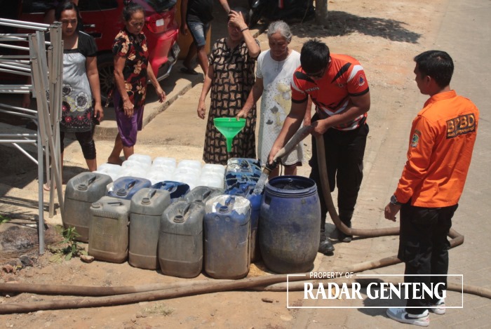 ANTRE: Warga mengantre mendapat kucuran air bersih dari mobil tangki milik BPBD Banyuwangi di Dusun Kebonrejo, Desa Kebondalem, Kecamatan Bangorejo, Rabu (11/10).