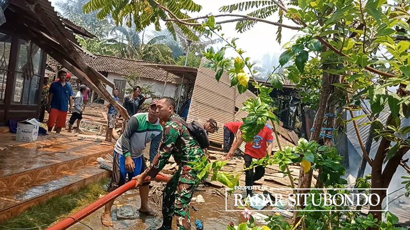PENUH ASAP: Warga bergotong royong memadamkan api di rumah Hadari, 65, warga Dusun Pariyaan, Desa Sopet, Kecamatan Jangkar, Situbondo, Senin (23/10) lalu.