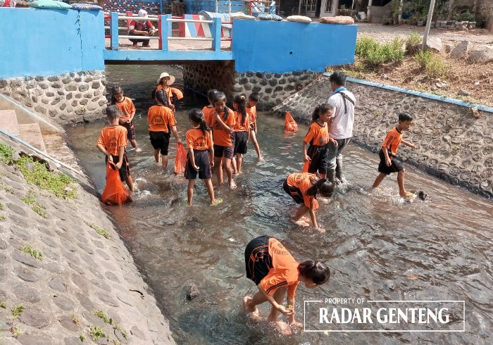 SEMARAK: Pegawai Korsda Genteng bersama siswa SDN 2 Kembiritan, Kecamatan Genteng membersihkan sungai di dekat sekolahnya, Rabu (25/10).