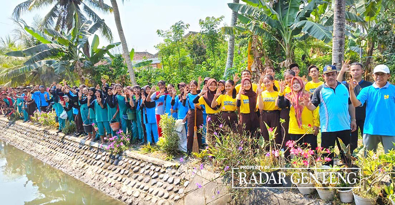 BERSIHKAN SUNGAI: Para Siswa SDN 1 dan SMPN 2 Tegaldlimo bersama petugas Korsda Tegaldlimo usai membersihkan sungai dan menanam bibit pohon kopi di dekat sekolahnya, Jumat (27/10)