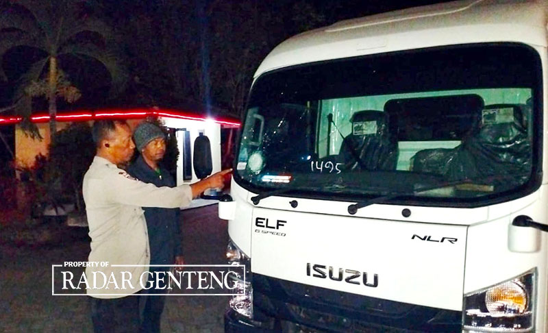 RUSAK: Anggota Polsek Glenmore mengecek mobil Izusu dengan plat nomor L 8030 NB yang kaca depan pecah akibat teror pelemparan batu di wilayah Kecamatan Glenmore pada Sabtu (28/10)