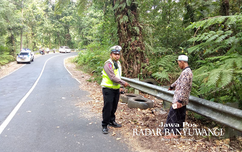 TIKUNGAN MAUT: Anggota Satlantas mengecek TKP kecelakaan yang menimpa tiga pelajar MTsN 3 Banyuwangi di jalur Sengkan Mayit, lereng Gunung Ijen, Minggu (30/10).