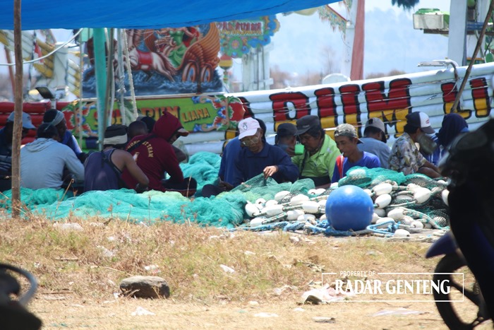 LIBUR: Para nelayan kapal slerek memperbaiki jaring di Pelabuhan Muncar, Desa Kedungrejo, Kecamatan Muncar Selasa (31/10).
