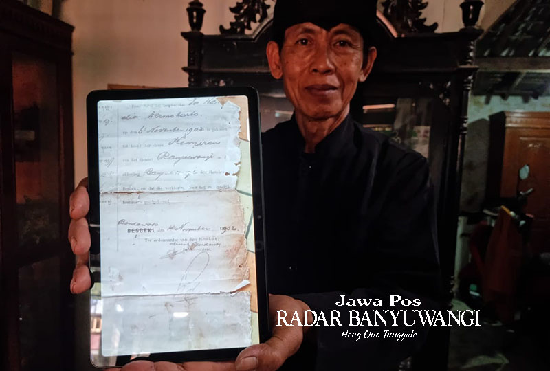 BUKTI OTENTIK: Ketua Lembaga Adat Masyarakat Using Kemiren Suhaimi menunjukkan dokumen yang menerangkan hari lahir Desa Kemiren.