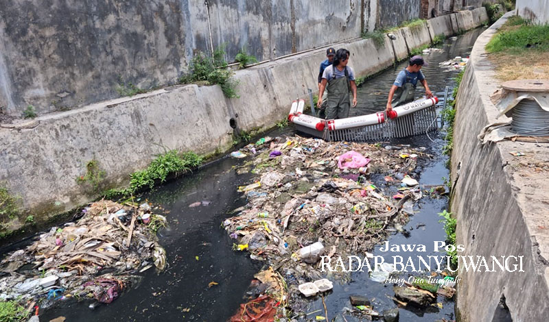 JAGA KEBERSIHAN SUNGAI: Relawan Sungai Watch memasang penahan sampah di sungai yang berada di Kelurahan Karangrejo, Banyuwangi.