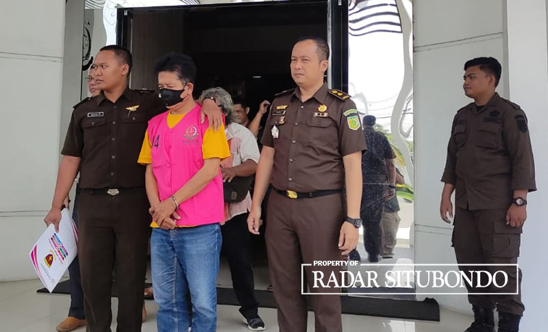 DILIMPAHKAN: Mantan Kepala Desa (Kades) Kotakan, Suriwan diapit tim Jaksa Penuntut Umum (JPU) di halaman Kantor Kejaksaan Negeri (Kejari) Situbondo, Selasa (7/11).