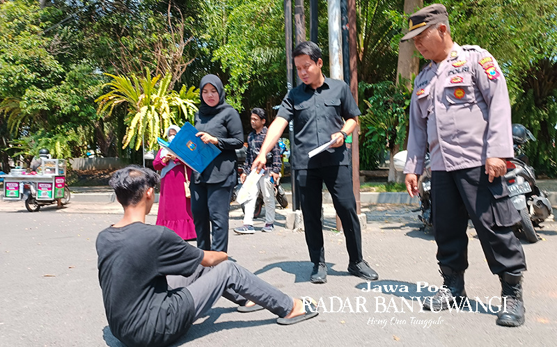 PELAKU MASIH MISTERIUS: Aparat kepolisian melakukan olah tempat kejadian perkara (TKP) kasus penganiayaan di depan TMP Banyuwangi, Selasa (7/11).