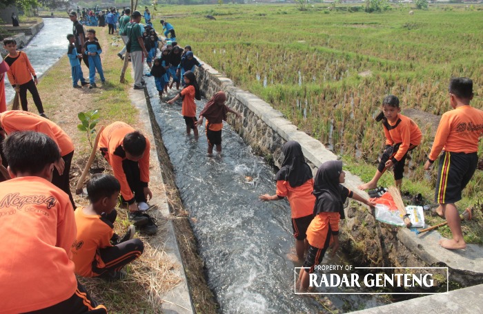 EDUKASI: Para siswa SDN IV Sumbergondo, SDN 1 Sumbergondo, dan MI Tarbiyatul Athfal bersih-bersih sungai di dekat sekolahnya Kamis (9/11).