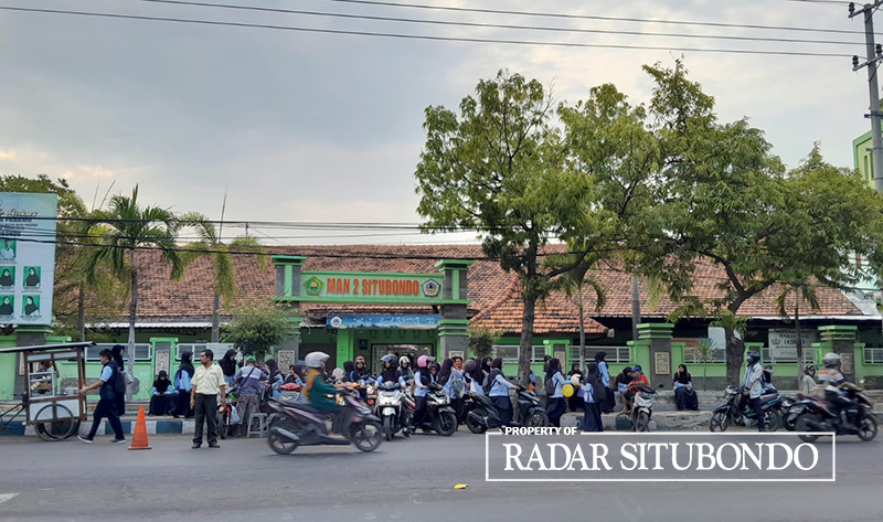 JAM PULANG: Satpam SMA 2 Situbondo mengatur keluarnya siswa-siswi di halaman gerbang sekolah, Kamis (9/10).
