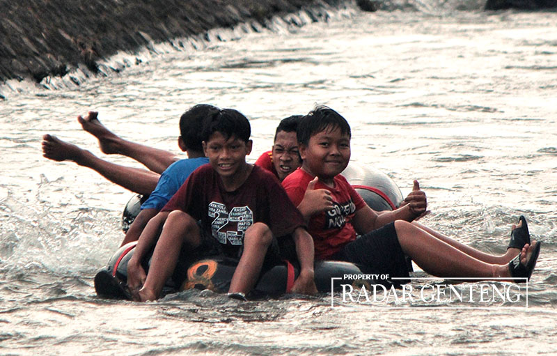 RIANG: Anak-anak bermain arung jeram menggunakan ban dalam bekas di sungai BP 2 di Dusun Salamerjo, Desa Sumbergondo, Kecamatan Glenmore, Jumat (10/11).