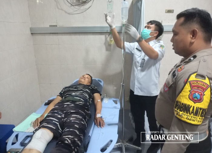 LUKA-LUKA: Unit Lantas Polsek Genteng Aipda Enrico Fernando mengecek kondisi Pelda Andik Avianto di RSUD Genteng setelah kecelakaan di jalan raya Desa Kembiritan, Kecamatan Genteng pada Senin (13/11)