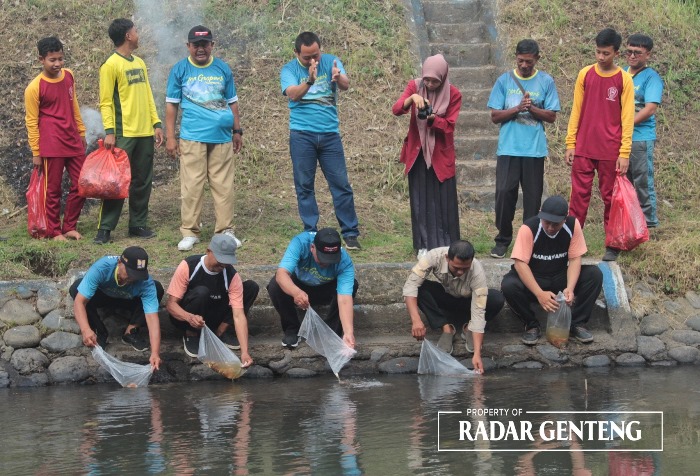 JAGA LINGKUNGAN: Korsda Genteng dan perwakilan MAN 2 Banyuwangi menebar 1.000 benih ikan nila di Saluran Cramber, Desa Genteng Kulon, Kecamatan Genteng Kamis (16/11).
