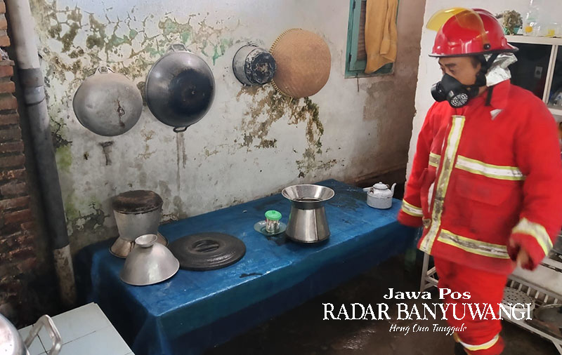 PAKAI PELINDUNG: Petugas Damkarmat Banyuwangi memastikan api yang membakar kompor warga di Kelurahan Kebalenan, Kecamatan Banyuwangi, telah padam Jumat (17/11).