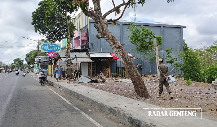 TINJAU: Anggota Satpol PP Genteng meninjau calon bangunan untuk lokasi Pujasera di Jalan KH Wahid Hasyim, Dusun Maron, Desa Genteng Kulon, Kecamatan Genteng Senin (20/11).