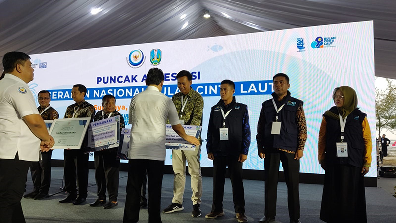 DAPAT APRESIASI: Ketua Pokdarwis Fish Market Kampung Mandar Hilman Syah Anwar (tengah) menerima hadiah satu unit mesin kapal tempel 8 PK di Surabaya, Jumat (10/11) lalu.