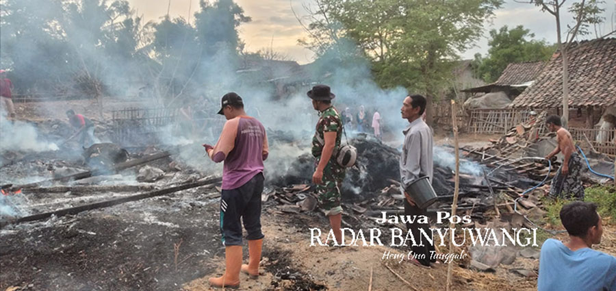 RATA DENGAN TANAH: Sejumlah warga memadamkan api di kandang sapi milik Nidin, 55, warga Desa Sumberkolak, Kecamatan Panarukan, Situbondo, Minggu (26/11).
