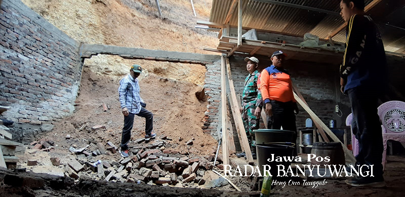 TINJAU LONGSOR: Anggota BPBD Situbondo meninjau dapur milik Jiwar 55, warga Dusun Taman Rejo, Desa Curahtatal, Kecamatan Arjasa, Senin (27/11).