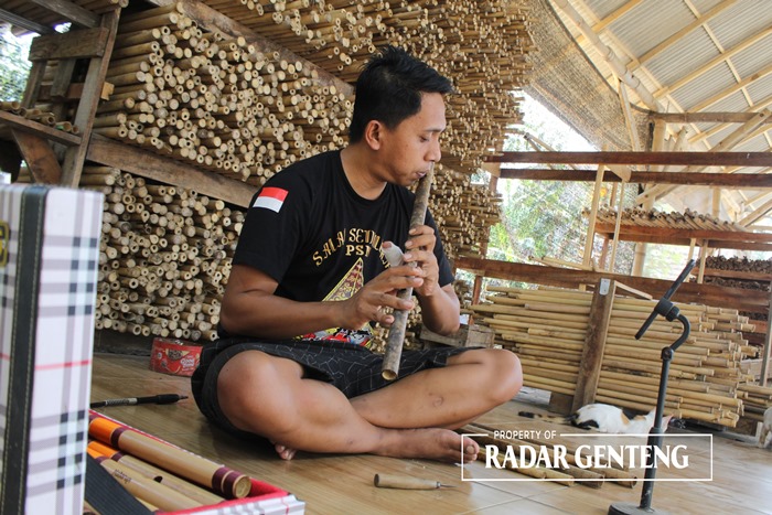 TELATEN: Iwan Pinanggih Saputra membuat seruling bambu di rumahnya di Dusun Sempu, Desa Sarimulyo, Kecamatan Cluring Selasa (27/11).