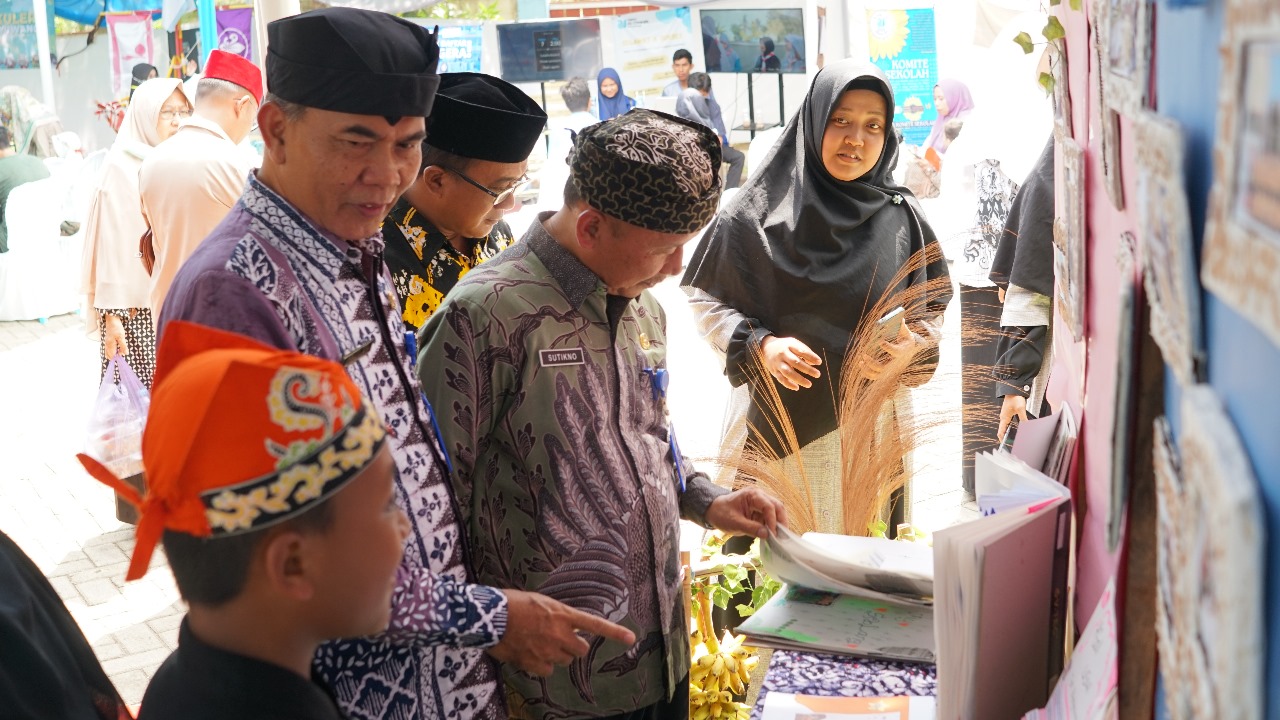 LIHAT HASIL KREASI: Kabid SD Dinas Pendidikan Banyuwangi Sutikno, didampingi Satkorwildik Janoto (kiri) saat hadir di acara open house SDIT Al Uswah 2, Lingkungan, Kebalenan, Banyuwangi, Sabtu (25/11)
