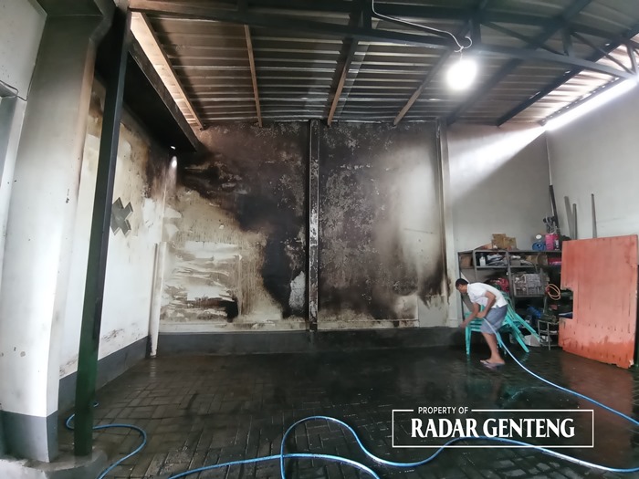 GOSONG: Pekerja membersihkan sisa-sisa kebakaran di garasi rumah milik distributor alat elektronik di Dusun Songgonrejo, Desa/Kecamatan Songgon, Minggu (3/12)