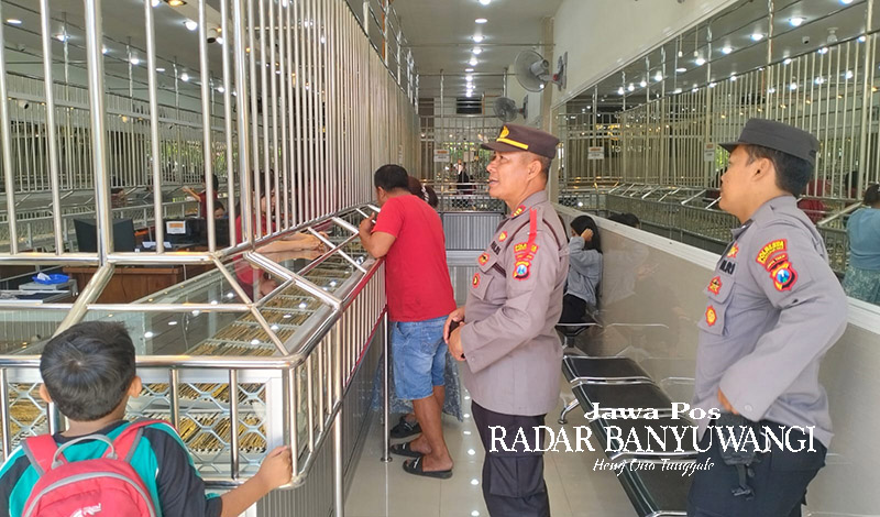 PATROLI: Kapolsek Banyuwangi AKP Kusmin bersama anggotanya memantau toko emas di Jalan Satsuit Tubun, Minggu (3/12).