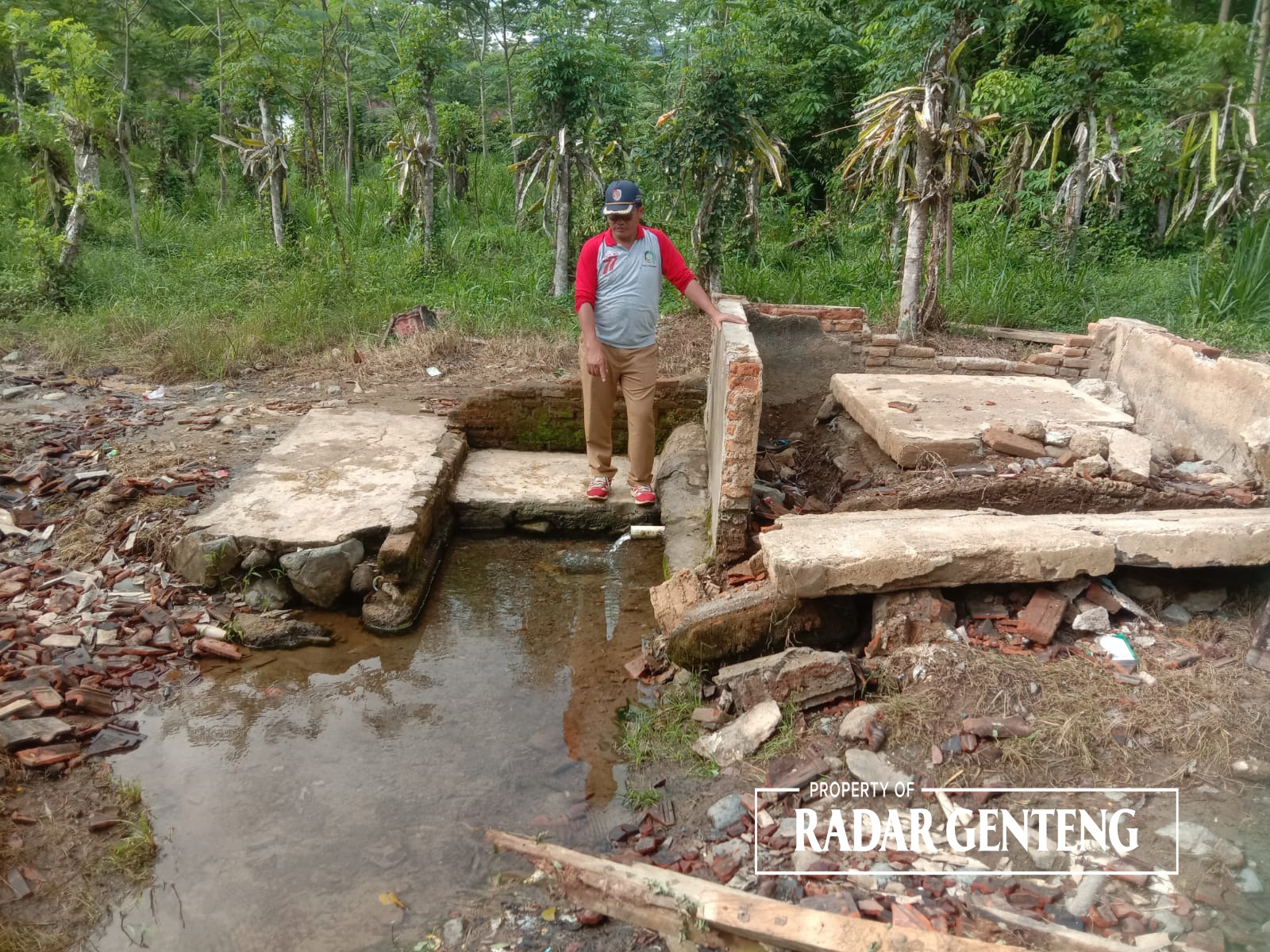 RUSAK: Kades Kandangan, Kecamatan Pesanggaran Riyono saat melihat bangunan sumber air di Afdeling Paal Empat yang ada di desanya rusak karena hujan Rabu (5/12).