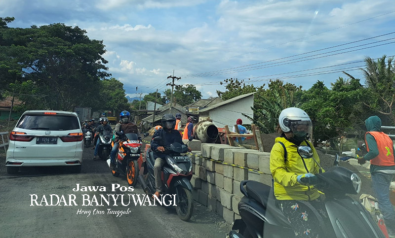 BUKA-TUTUP: Kendaraan roda empat dan roda dua melintas di atas jembatan Wongsorejo yang sedang dalam proses perbaikan, Kamis (7/12).