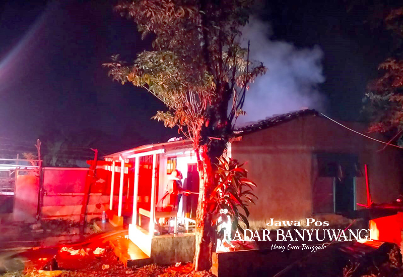 TERBAKAR: Asap membubung di atas rumah Niswati di Dusun Krajan, Desa Pengatigan, Rogojampi, Banyuwangi, Selasa malam (12/12).