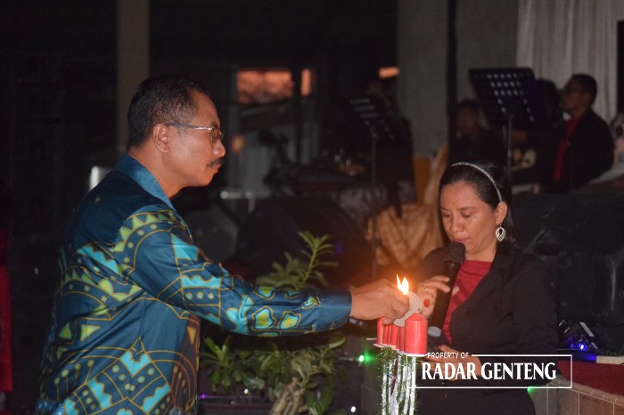 TERANG: Pendeta GKJW Tulungrejo Sutrijo (kiri) menyalakan lilin natal di Desa Jajag, Kecamatan Gambiran Rabu (13/12).