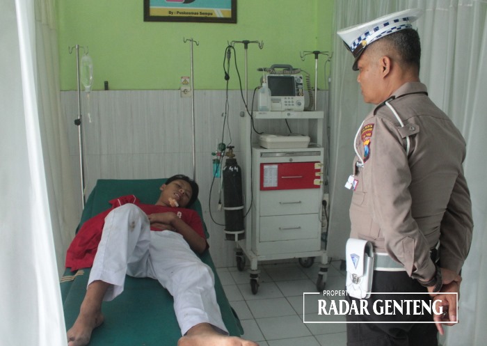 RAWAT: Anggota Unit Lantas Polsek Genteng saat melihat M Rochman yang dirawat di Puskesmas Sempu setelah kecelakaan di Jalan Raya Kalisetail, Dusun Krajan, Desa/Kecamatan Sempu Kamis (14/12).