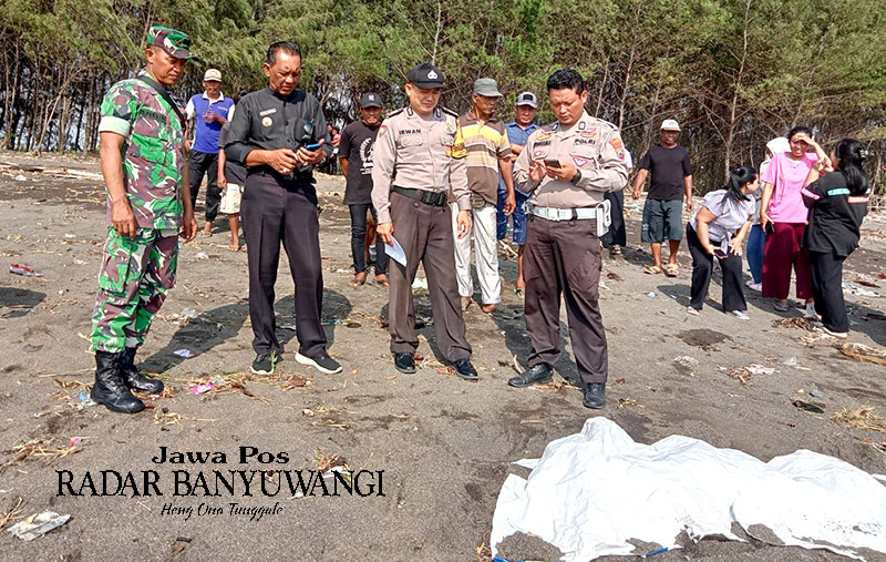 SEBELUM DIEVAKUASI: Aparat Polsek dan Koramil Rogojampi bersama Kepala Desa Bomo melakukan identifikasi jenazah yang ditemukan di Pantai Ria Bomo, Kamis (14/12).