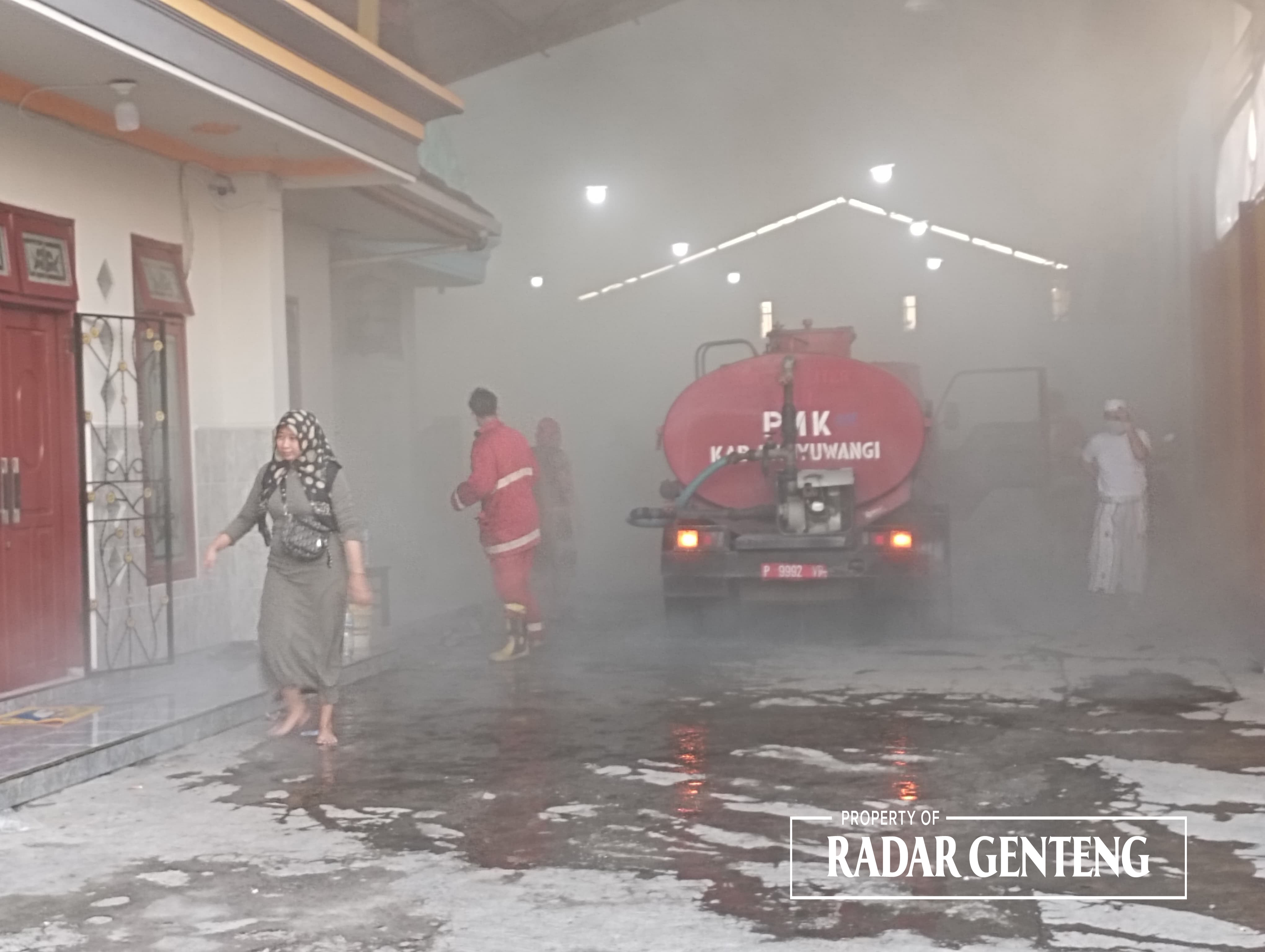 ASAP TEBAL: Petugas Damkar Sektor Srono berusaha memadamkan api di gudang penyimpanan ikan di Dusun Palurejo, Desa Tembokrejo, Kecamatan Muncar Selasa (19/18) Sore.