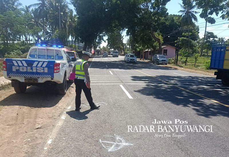 LOKASI KECELAKAAN: Anggota Satlantas Polresta Banyuwangi melakukan olah tempat kejadian perkara di jalan raya Desa Dadapan, Kabat, Banyuwangi, Minggu (24/12).