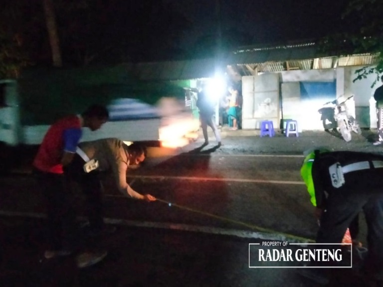 TKP: Anggota Unit Lantas Polsek Genteng olah TKP kecelakaan lalu lintas di jalan raya Dusun Krajan Wetan, Desa Temuguruh, Kecamatan Sempu pada Senin (25/12) malam.