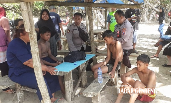 SELAMAT: Anggota Polsek Pesanggaran saat mengecek kondisi tiga bocah selamat setelah tenggelam di Palung Karim sebelah barat Pantai Pulau Merah, Dusun Pancer, Desa Sumberagung, Kecamatan Pesanggaran.