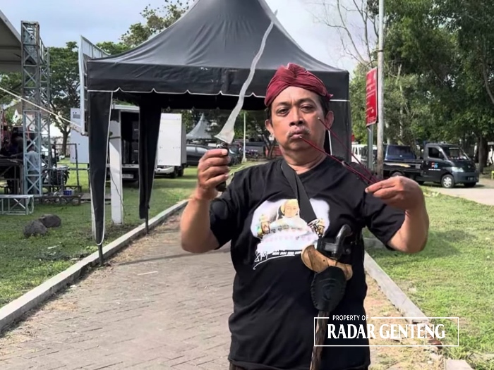 RITUAL: KRT Ilham Triadi Nagoro membaca doa-doa sambil memegang keris untuk menunda hujan di RTH Maron, Desa Genteng Kulon, Kecamatan Genteng pada Selasa (26/12) sore.