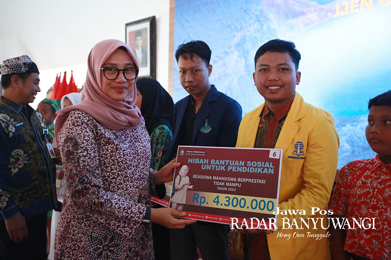SIMBOLIS: Bupati Ipuk Fiestiandani didampingi Kadispendik Suratno menyerahkan bansos kepada mahasiswa berprestasi kategori tidak mampu di Pendapa Sabha Swagata Blambangan, Jumat (29/12).