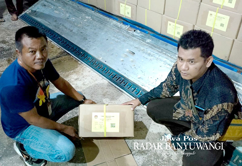 BARU TIBA: Ariyanto (kiri) bersama staf Bawaslu membongkar logistik surat suara yang tiba di gudang logistik KPU Banyuwangi, Jumat (29/12).