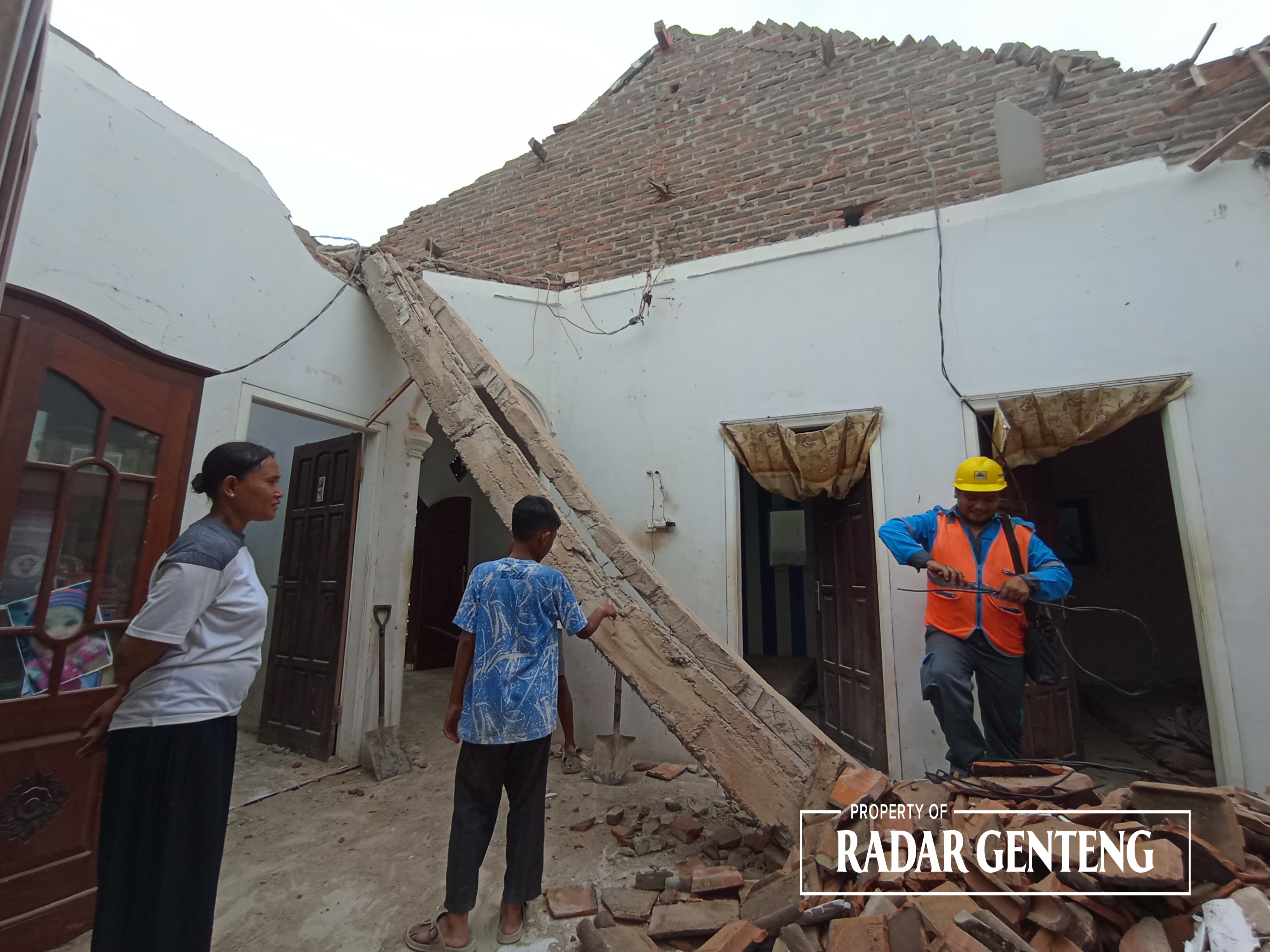 MENDADAK ROBOH: Petugas PLN memperbaiki jaringan listrik di rumah Suminten di Dusun Bongkoran, Desa Parijatah Wetan, Kecamatan Srono yang mendadak ambruk Rabu (3/1).