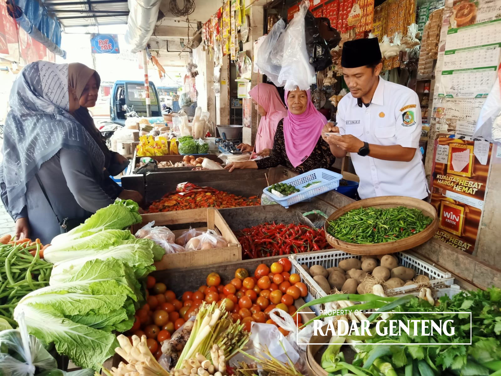 CATAT: Arif Kurniawan mencatat harga bahan pokok di Pasar Genteng 1, Desa Genteng Kulon, Kecamatan Genteng Rabu (3/1)