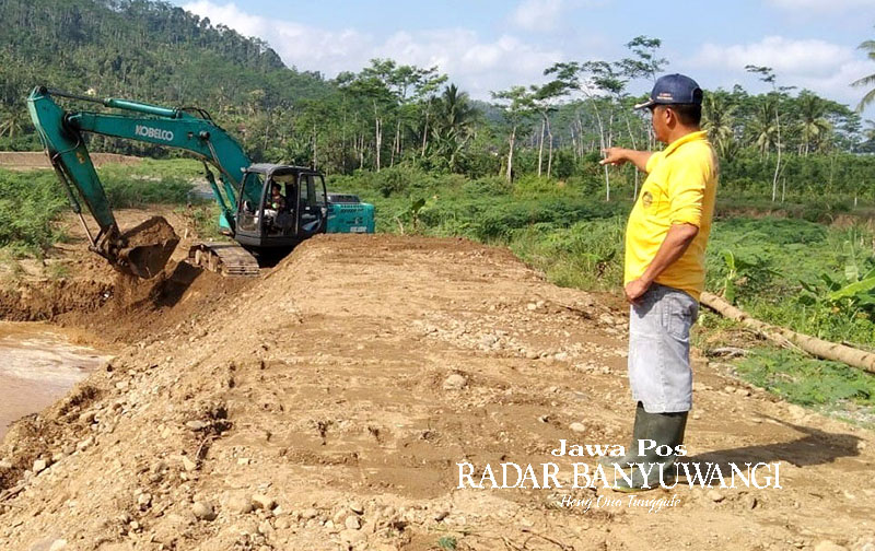 URUK: Jalan yang putus di Afdeling Paal Empat dan Afdeling Paal Enam, Dusun Sumberjambe, Desa Kandangan, Kecamatan Pesanggaran diuruk menggunakan alat berat, Jumat (5/1).