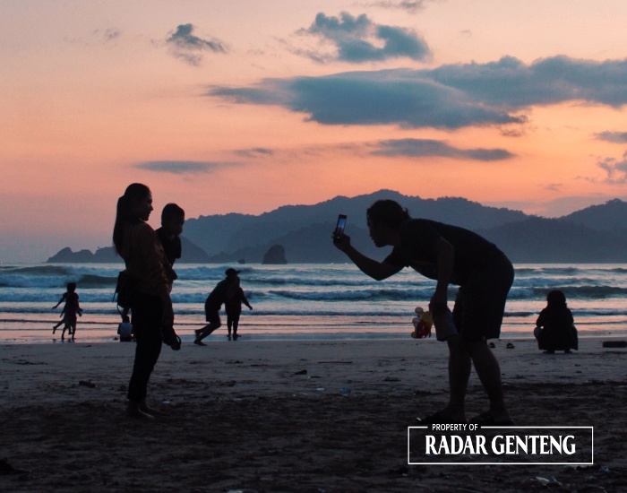 SUNSET: Pengunjung Pantai Pulau Merah di Dusun Pancer, Desa Sumberagung, Kecamatan Pesanggaran menikmati terbenamnya matahri sambil swafoto pada Sabtu (6/1) sore.