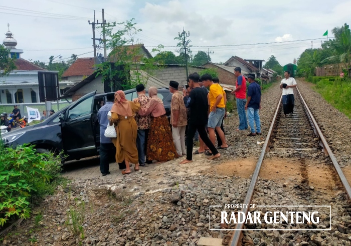 DORONG: Warga membantu korban kecelakaan KA dengan mendorong mobil Toyota Innova milik H Khusnan Abadi menjauh dari rel kereta api di perlintasan tanpa palang pintu Dusun Sepanjang Wetan.Minggu (14/1)