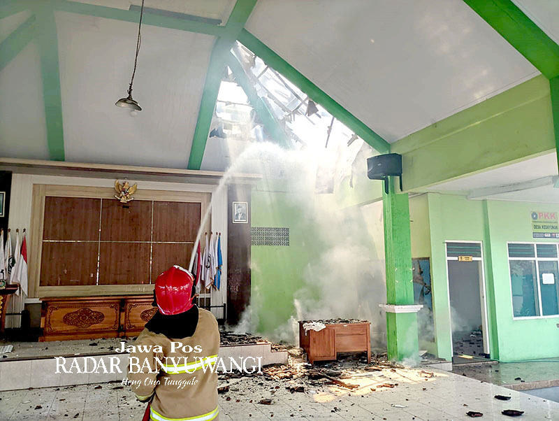 SEMPROTKAN AIR: Petugas Damkarmat berjibaku memadamkan api yang membakar atap pendapa kantor Desa Kedayunan, Kecamatan Kabat, Minggu (21/1).