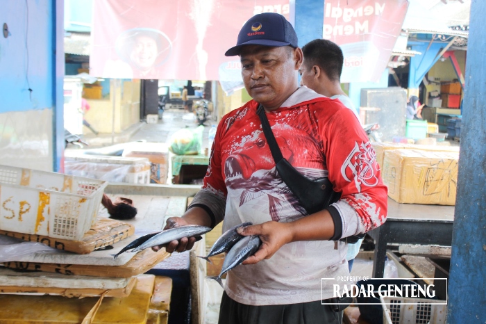 NAIK: Pedagang ikan di Pasar Brak Kalimoro, Desa Kedungrejo, Kecamatan Muncar menunjukkan ikan hasil tangkapan nelayan Rabu (24/1).