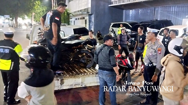 DIANGKUT KE POLRESTA: Personel Satlantas mengamankan segala jenis sepeda motor di depan kantor Pemkab Banyuwangi, Sabtu malam (27/1).