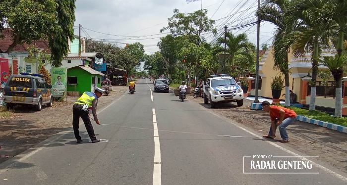 TKP: Anggota Unit Lantas Polsek Genteng olah TKP kecelakaan yang menewaskan satu pemotor di jalan raya Desa Kembiritan, Kecamatan Genteng Minggu (28/1) siang.