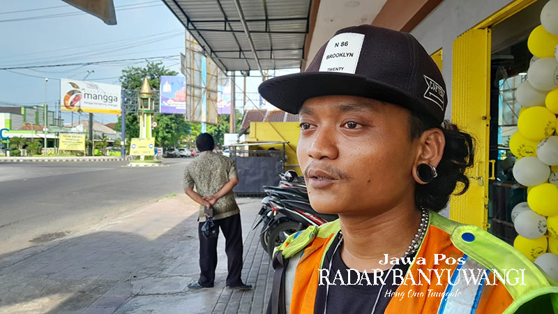 ATUR PENGEMUDI: Moh Riski Hamdan Mubarok, warga Karawang, Jawa Barat, menjaga lahan parkir di depan toko Jl. PB Sudirman, Lingkungan Karangasem, Situbondo, Kamis (1/2).