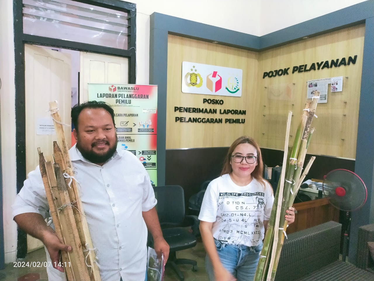 BAWA BUKTI: Tim kuasa hukum Sumail Center, Amrullah dan Eny Setyawati, menunjukkan kayu dan bambu sisa APK yang dirusak ke kantor Bawaslu Banyuwangi, Rabu(7/2).