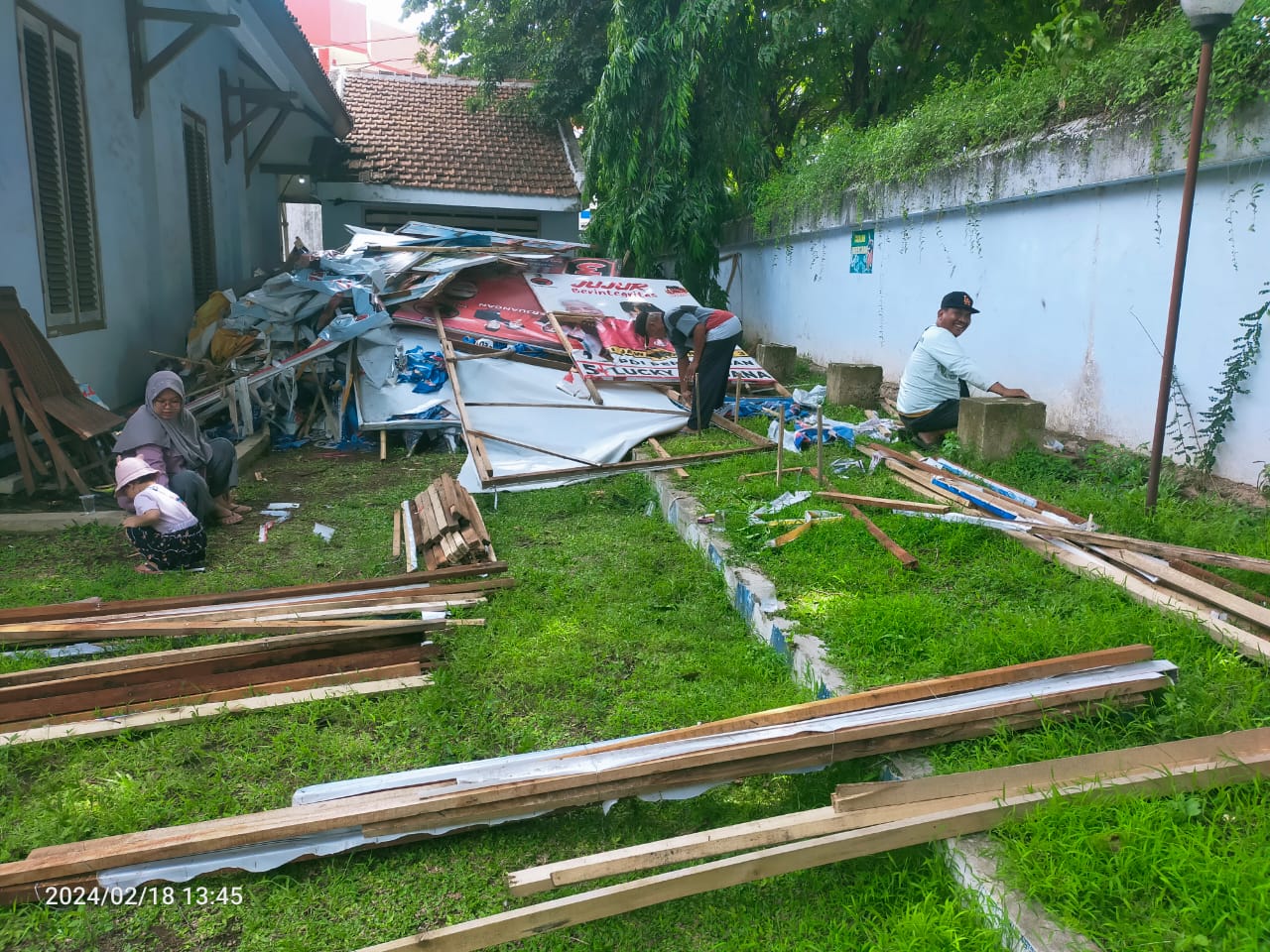 BERBURU: Sejumlah warga berburu kayu dan banner sisa APK di kantor Kecamatan Rogojampi, Minggu (18/2)